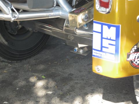 1986 Ford Bronco - A gold SUV's rear quarter panel displays various decals, including "IMS INDUSTRIAL SUPPLY CO." and a "Jiffy" logo.