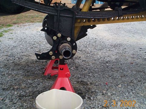 1978 Ford Bronco - Close-up of a vehicle's front axle hub and brake assembly on jack stands.