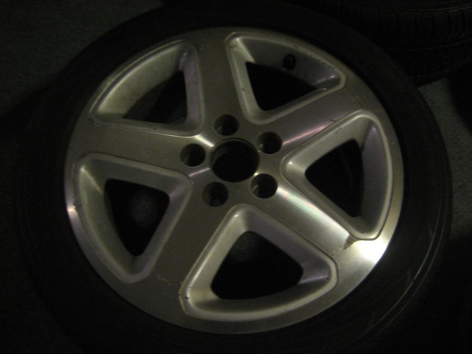 Silver 5-spoke alloy wheel with black tire