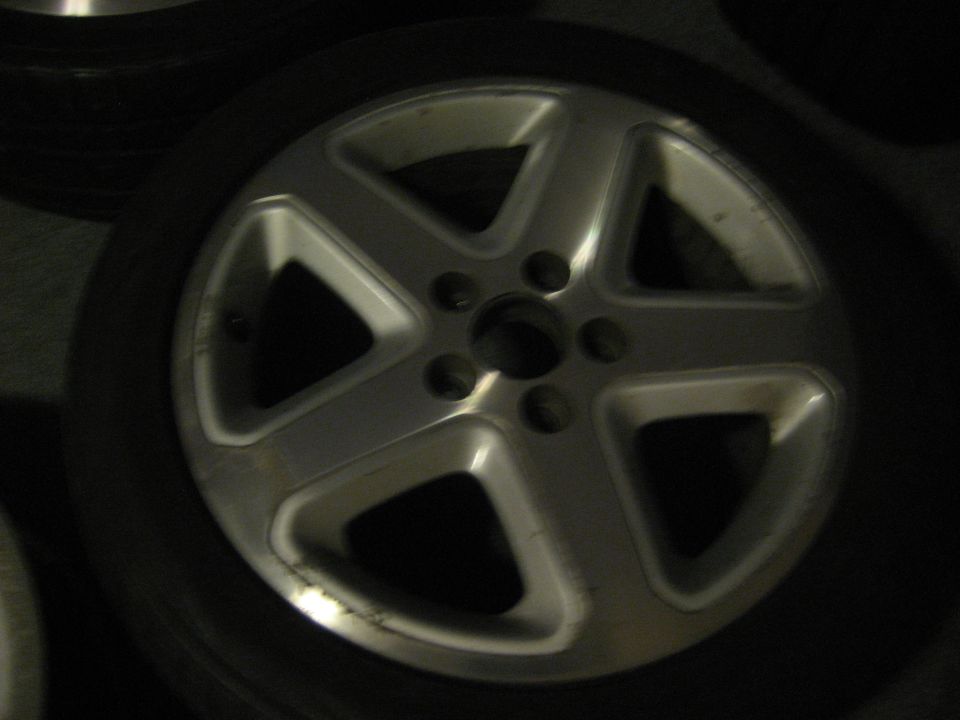 Close-up of a five-spoke alloy car wheel with a tire