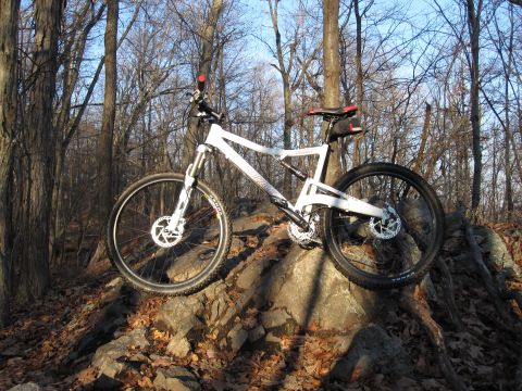 1981 Garelli Rally Sport - A white mountain bike is parked on a rocky trail surrounded by trees in the fall.
