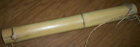 1993 Ford Bronco - A handmade bamboo arrow quiver, a hollow yellow bamboo tube with visible growth nodes, bound at the open end with twine and a braided natur…