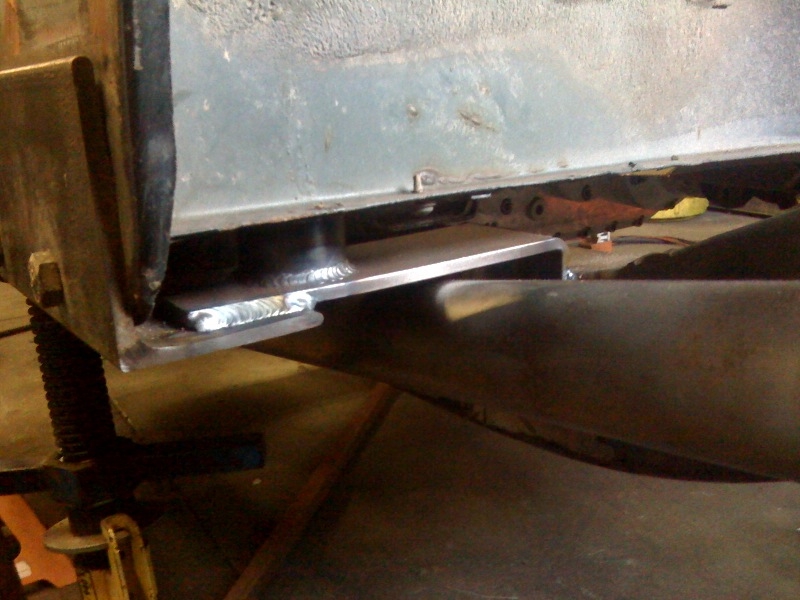 Welded metal bracket attached to vehicle frame, close-up view