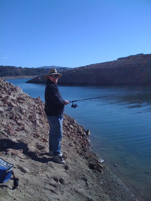 1968 Ford Mustang - A person enjoys a sunny day fishing by the water's edge.