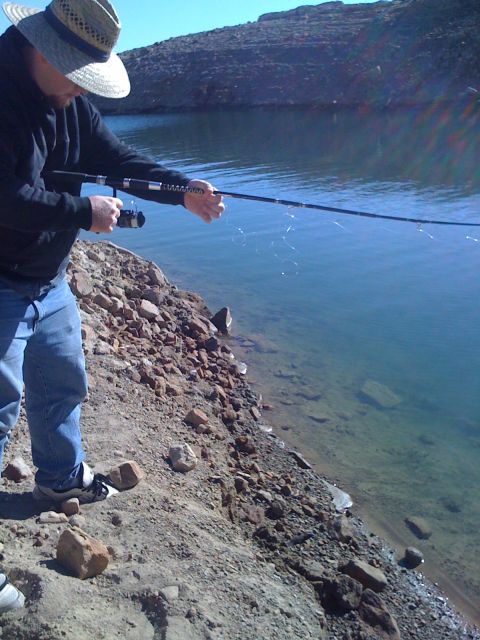 1968 Ford Mustang - A person enjoys a sunny day fishing by the clear blue water of a lake.