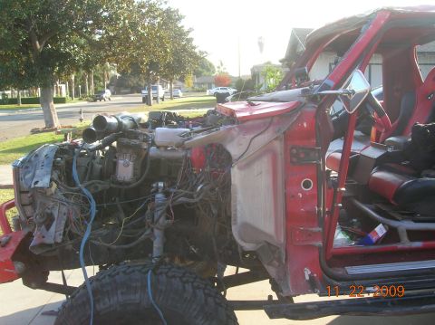 1985 Ford Bronco - This heavily modified red off-road vehicle shows its exposed engine and racing seats, with a date stamp of 11 22 2009.