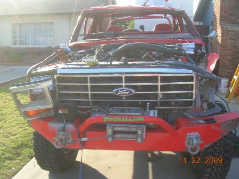 1985 Ford Bronco - This heavily modified Ford truck features a prominent grille and a winch mounted on its custom front bumper.