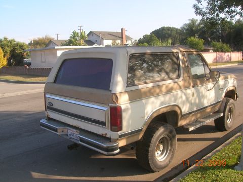 1985 Ford Bronco - This 1985 Ford Bronco is seen from the rear three-quarter angle, a two-tone brown and white paint scheme.