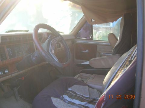 1985 Ford Bronco - The interior of an older vehicle shows a dated dashboard and worn seats.