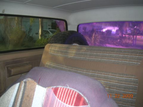 1985 Ford Bronco - Interior view with a spare tire and a glimpse of another vehicle outside.