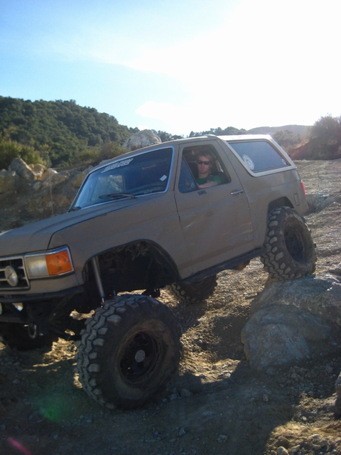 1989 Ford Bronco - This lifted 1989 Ford Bronco is shown off-roading over a rocky trail.
