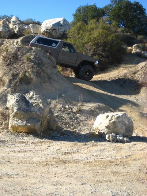 1989 Ford Bronco - This SUV is tackling a challenging off-road course with steep inclines and large rocks.