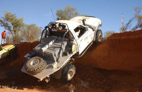 2002 Ford F-350 - Modified 2002 Ford F-350 tackles a challenging off-road climb in a desert landscape.