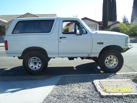 1995 Ford Bronco - This white 1995 Ford Bronco is shown from the side, parked on a suburban street.