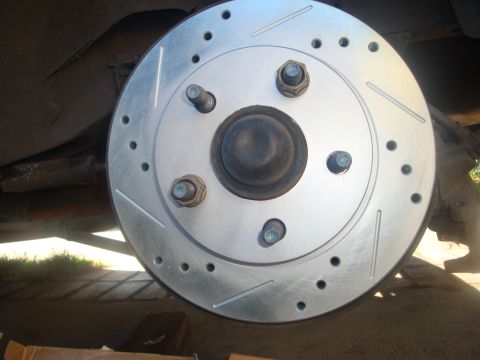 1995 Ford Taurus - New slotted and drilled brake rotor installed on a vehicle.