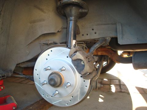 1995 Ford Taurus - New drilled and slotted brake rotor and caliper assembly on a vehicle's suspension.