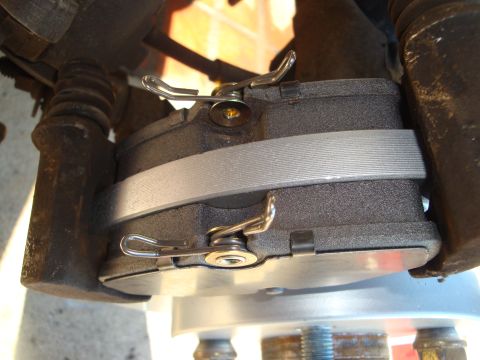 1995 Ford Taurus - A detailed view of a vehicle's brake system, focusing on the caliper and pads.
