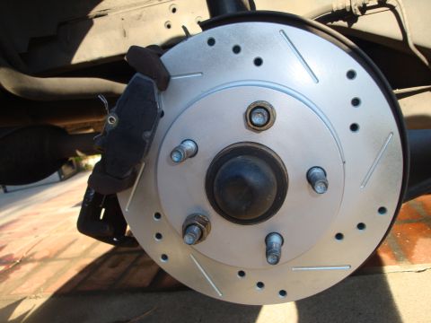 1995 Ford Taurus - Close-up of a slotted and drilled brake rotor with a caliper, likely a rear brake assembly.