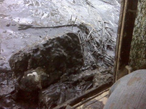 1992 Ford F-350 - A muddy scene with debris, possibly a construction or off-road environment, viewed from a vehicle's interior.