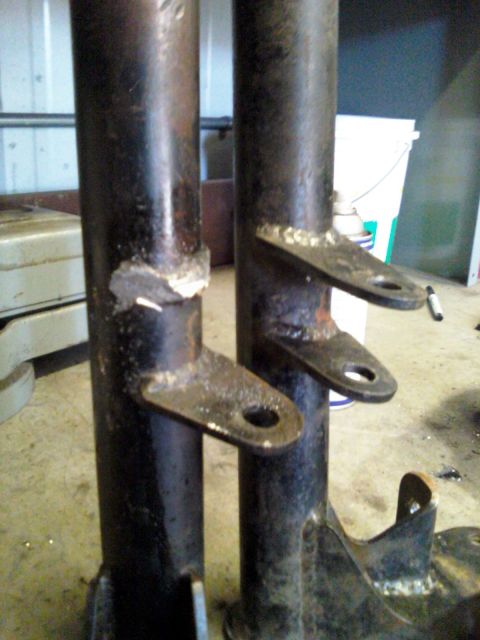 1984 Ford Bronco - Close-up of two suspension shock absorbers with welded mounting brackets.