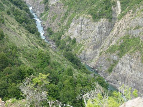 1986 Ford Bronco - A scenic view of a river winding through a deep canyon, surrounded by lush green vegetation and cliffs.