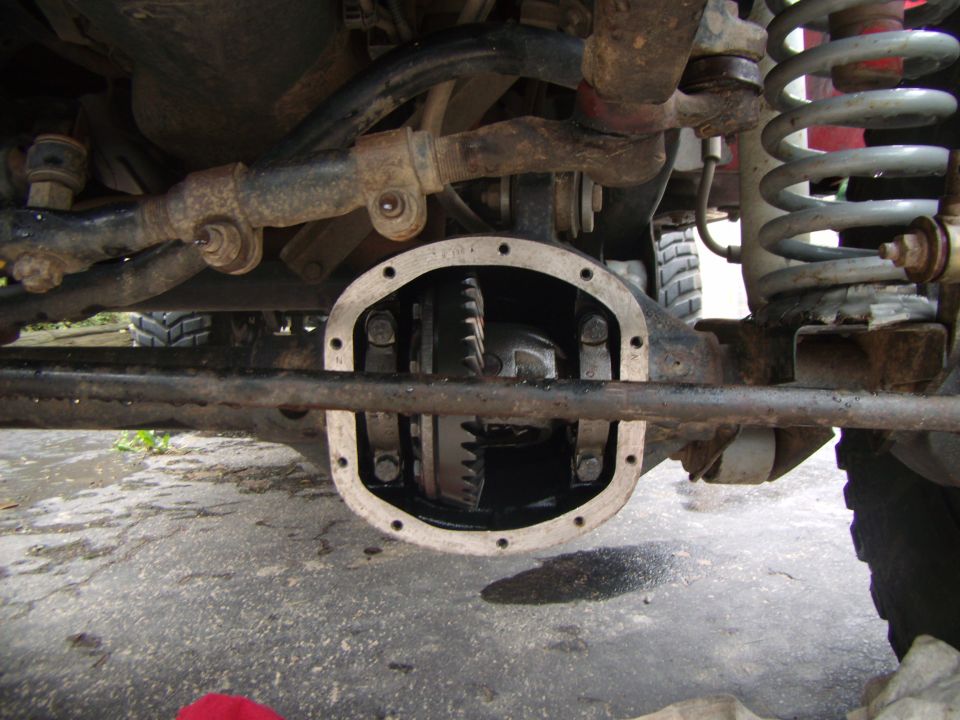Differential cover removed, showing gears and suspension components of a vehicle