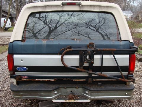 1993 Ford Bronco - Rear view of a 1993 Ford Bronco, showing the tailgate, bumper, and a spare tire carrier mount.
