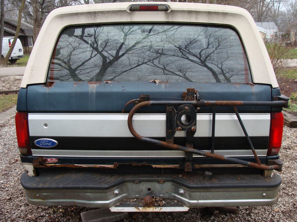 1993 Ford Bronco rear view showing tailgate, bumper, and spare tire carrier. Ford badge visible