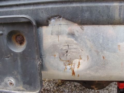 1993 Ford Bronco - Close-up of a damaged rear bumper and license plate bracket, showing signs of wear and tear.