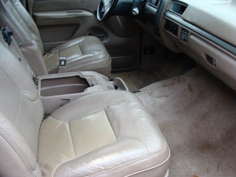 1993 Ford Bronco - The interior of a 1992 Ford Bronco shows tan leather seats and worn carpet.