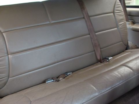 1993 Ford Bronco - Close-up of the rear bench seat and seatbelts inside a vehicle.