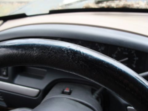 1993 Ford Bronco - Interior view of a 1993 Ford Bronco, focusing on the worn steering wheel and dashboard.