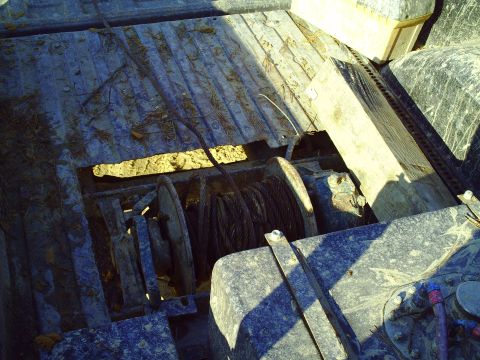 1990 Ford Bronco - A winch mechanism is visible in the bed of a dirty truck, with the Supermotors logo in the lower right corner.