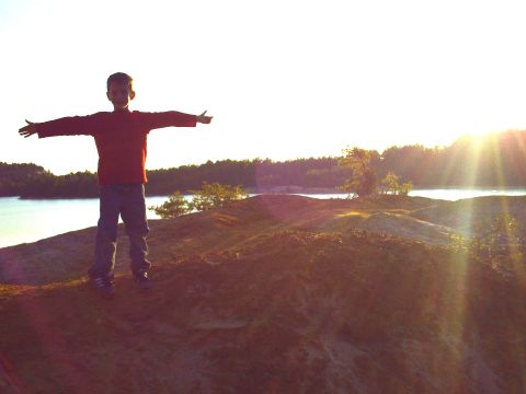1990 Ford Bronco - A young boy enjoys the view of a lake during a golden hour sunset.