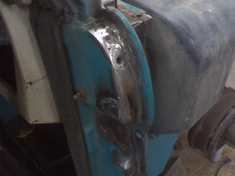 1972 Ford Bronco - Detail of a vehicle's door hinge area, showing metal repair and paint.