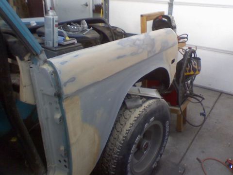 1972 Ford Bronco - A 1972 Ford Bronco fender is being prepped for paint, revealing its underlying structure and a tire.