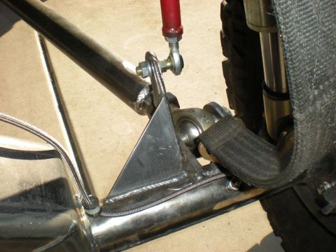 Suzuki Samurai - Welded stainless suspension bracket with a red heim-joint link and nylon limit strap on a tube chassis.
