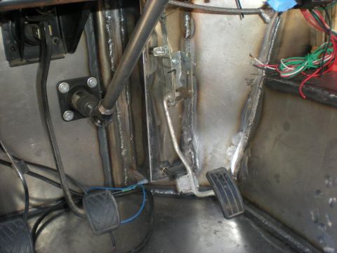 Suzuki Samurai - The interior of a vehicle displays pedals, wiring, and a steering column, with visible welding.