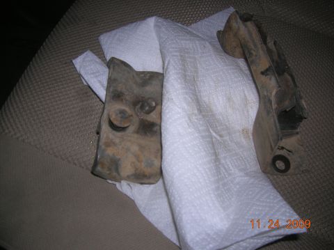 1985 Ford Bronco - Two rusty metal components are placed on white paper towels, resting on a textured seat. A date stamp reads 11.24.2009.
