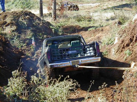 1994 Ford Explorer - A dark pickup truck maneuvers through a challenging off-road course, with another vehicle visible in the background.