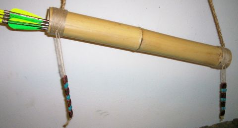 1993 Ford Bronco - A full-length handmade bamboo quiver hung horizontally on a white wall by a braided cord sling, with twine wrappings at both ends and beade…
