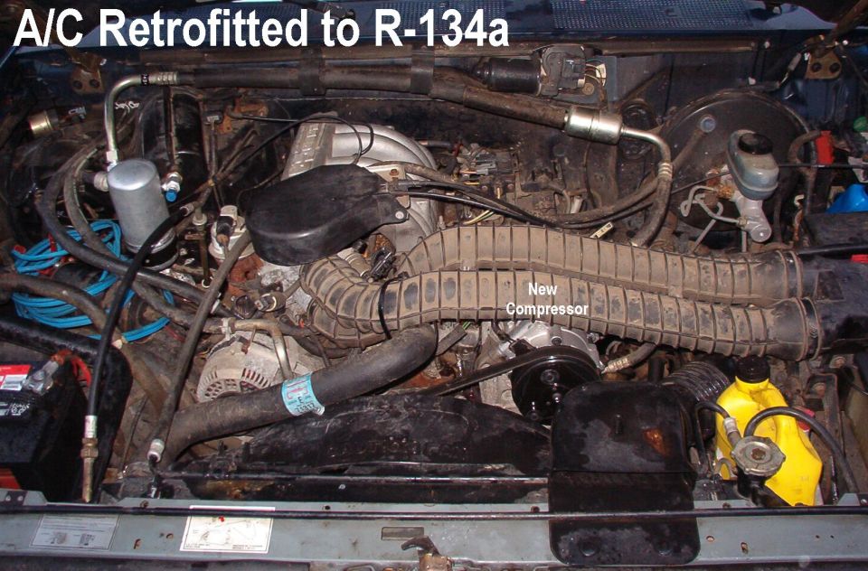 Truck engine bay showing A/C system retrofitted to R-134a refrigerant