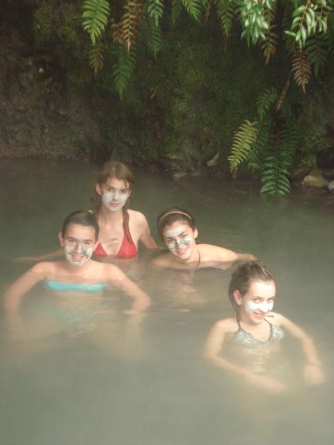 1986 Ford Bronco - Four friends enjoy a relaxing mud bath in a natural hot spring surrounded by lush greenery.
