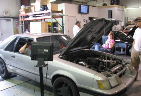 1986 Ford Mustang - Silver 1986 Ford Mustang undergoing testing on a dynamometer in a garage setting.