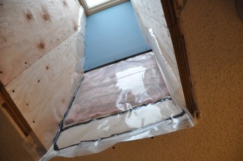 1996 Ford Bronco - Looking up into a framed skylight shaft in a stucco-textured ceiling, with plywood-sheathed sides, pink fiberglass batt insulation sealed b…