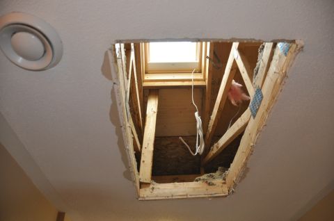 1996 Ford Bronco - A rough opening in the ceiling reveals framing and a small skylight, with insulation visible.