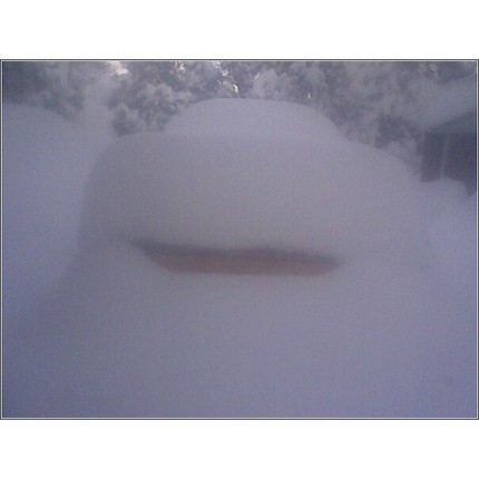 1973 Ford Ranchero - A vehicle is completely buried under a thick layer of snow, obscuring its make and model.