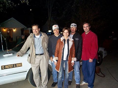 1997 Ford Crown Victoria - Five people pose with a 1997 Ford Crown Victoria, which has a 'TO PROTECT & SERVE' decal on its side.