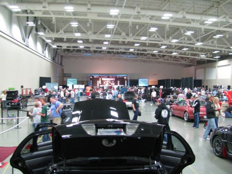 2003 Mercury Marauder - A black sedan with its trunk and doors open is displayed at an indoor car show with many other vehicles and attendees.
