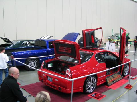 2003 Mercury Marauder - Customized red coupe with doors and trunk open at a car show, alongside other vehicles.